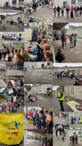 Kolāža, kas attēlo skolas āra pasākumu, kurā bērni un pieaugušie piedalās KiVa programmas aktivitātēs. Uz zemes ar krītu rakstīts "MĒS ESAM KIVA SKOLA". Daži bērni sēž, citi stāv grupās vai zīmē. Pieaugušie dzeltenās vestēs vada pasākumu. Redzama dzeltena soma ar KiVa logotipu un uzrakstu "EU 2027".